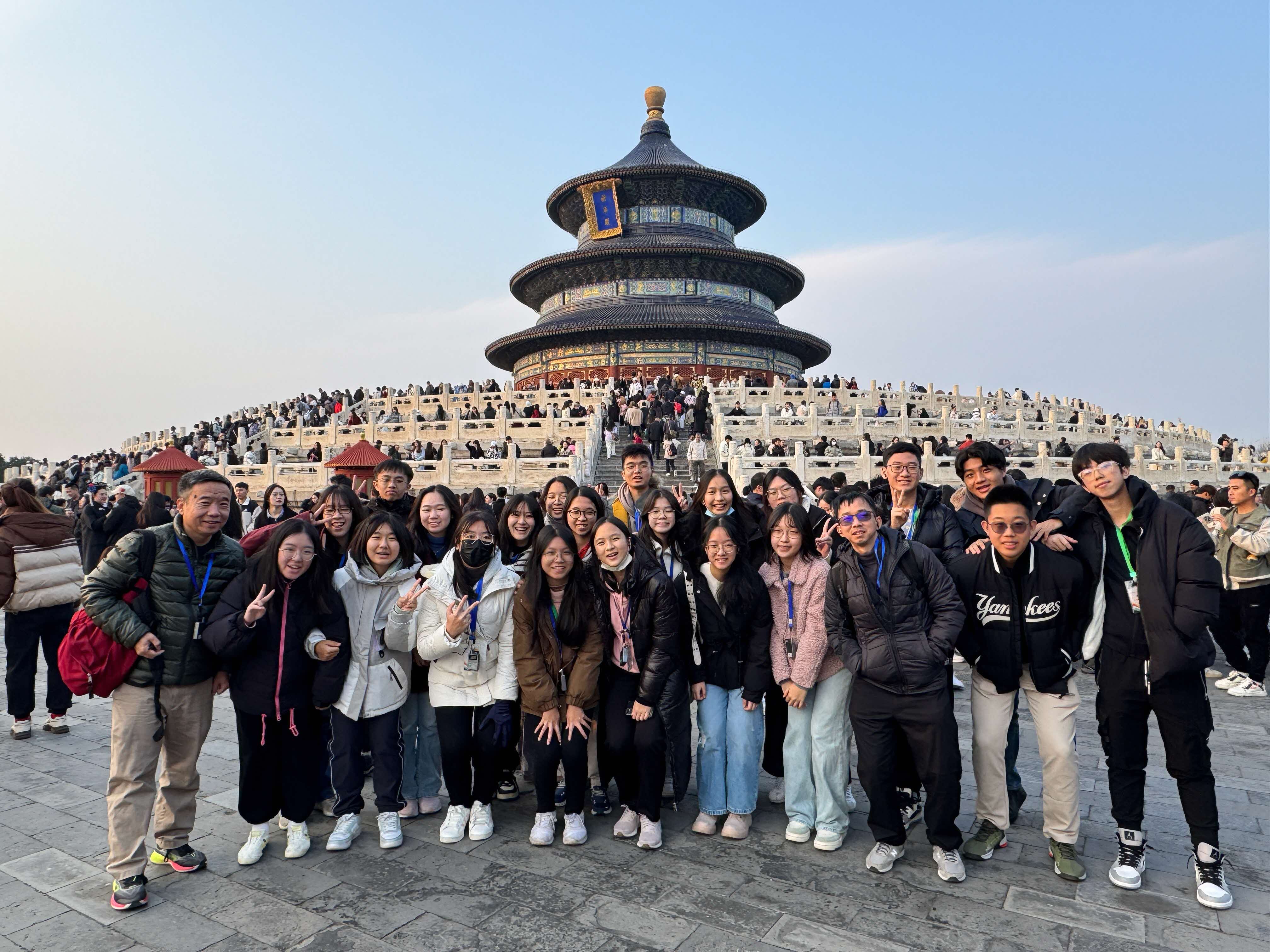 A group of students and teachers posing in front of the Temple of Heaven in Beijing.